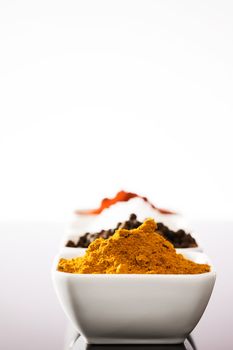 closeup of curry in a small bowl in front of other spices