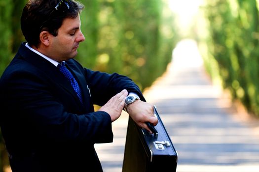 View of a young male business man on a asphalt road.