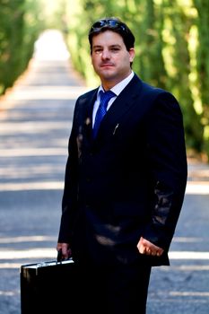 View of a young male business man on a asphalt road.