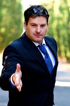 View of a young male business man on a asphalt road.