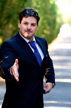 View of a young male business man on a asphalt road.