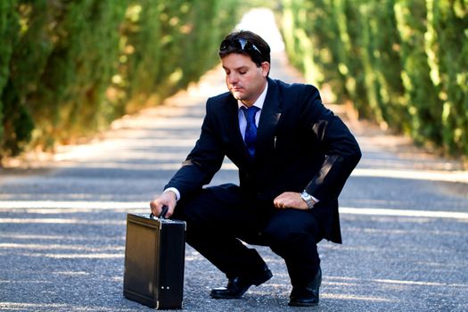View of a young male business man on a asphalt road.
