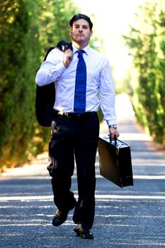 View of a young male business man on a asphalt road.
