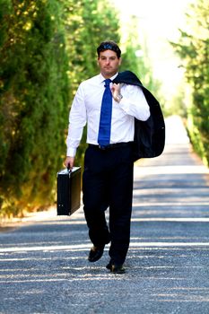 View of a young male business man on a asphalt road.