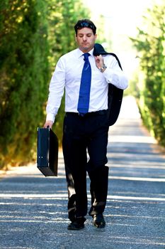 View of a young male business man on a asphalt road.