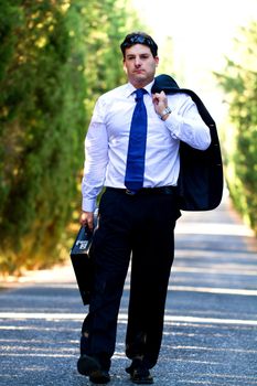 View of a young male business man on a asphalt road.