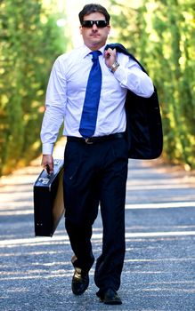 View of a young male business man on a asphalt road.