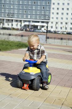 baby boy playing with toy auto on playground
