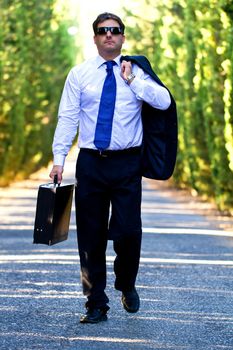 View of a young male business man on a asphalt road.