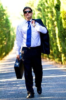 View of a young male business man on a asphalt road.
