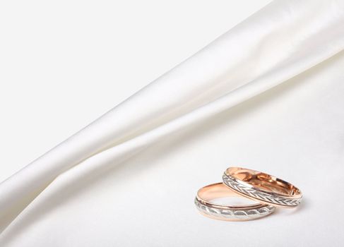 wedding rings on white silk background