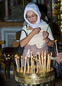 JERUSALEM - NOVEMBER 03 2011 - A pilgrim prays by candelelight in the church of the holy sepulcher in Jrusalem Israel 