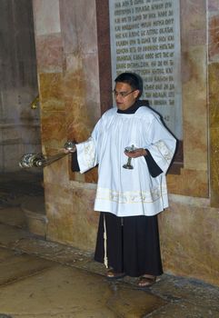 JERUSALEM - NOVEMBER 03 2011 - Thurible held by altar server in the church of the holy sepulcher in Jrusalem Israel 