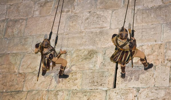 JERUSALEM - NOV 03 : An Israeli acrobats dressed as knight climbing on the old city walls in the annual medieval style knight festival held in the old city of Jerusalem on November 03 2011