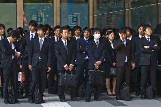 TOKYO - OCT 29 : Japanese office workers stands outside an office building in Tokyo Japan financial district on October 29 2009 