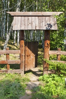 Wooden wicket on birch grove background, sunny summer day