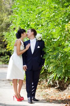 bride and groom near the bush