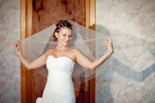 young bride with veil in hands