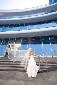 happy bride on the staircase with flying veil