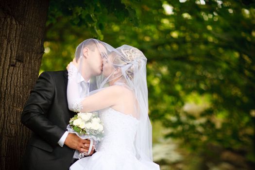 kiss of bride and groom outdoors