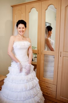 smiling bride near the cabinet