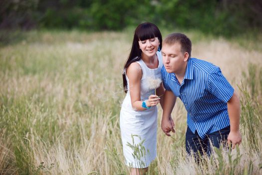 couple blowing on the dandelion