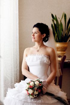 bride waiting for a groom near the window