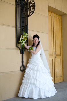 beautiful bride standing near the wall