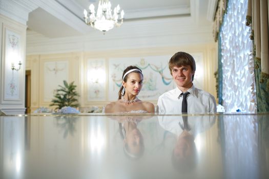 happy bride and groom at the piano