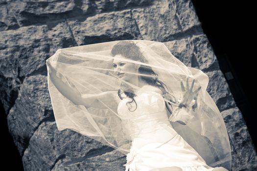 bride near the stone wall in black and white