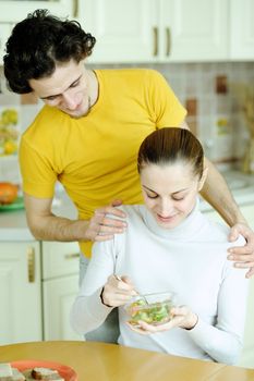 An image of young couple eating at kitchen