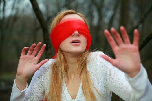 An image of a girl with red scarf on her eyes