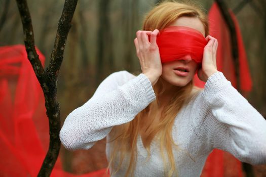 An image of young woman with red blindfold