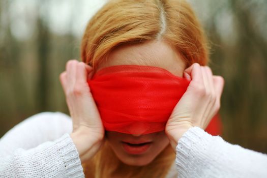 An image of blindfolded woman in the forest