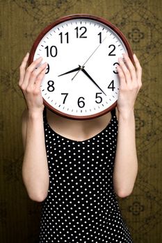 An image of a girl holding a big white clock