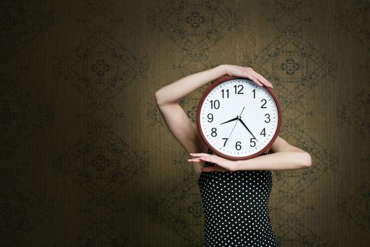 An image of a girl holding a big white clock