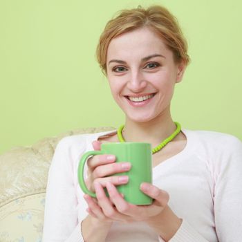 An image of happy woman with green cup