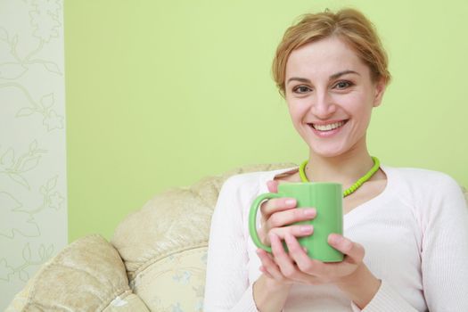 An image of happy woman with green cup