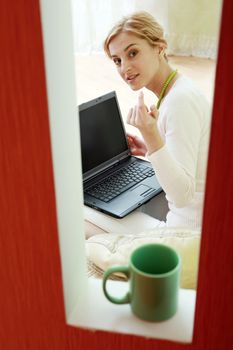 An image of a woman with laptop at home