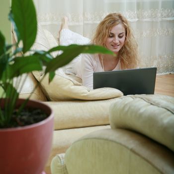 An image of a nice woman with laptop on a sofa