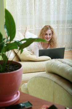 An image of a nice woman with laptop on a sofa