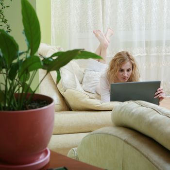 An image of a nice woman with laptop on a sofa