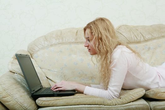 An image of nice girl with laptop on a sofa