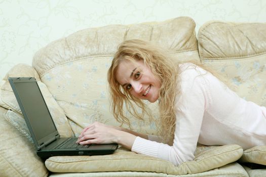 An image of a nice girl with laptop on a sofa