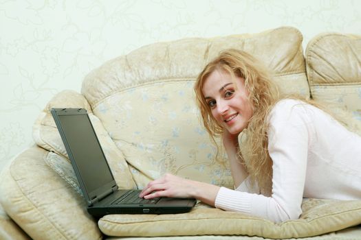 An image of a nice girl with laptop on a sofa