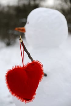 An image of snowman with red heart