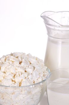 Jug with milk, a glass and a dish with cottage cheese