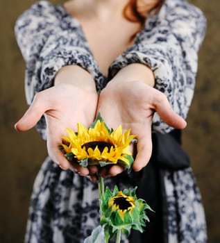 An image of young woman with sunflower