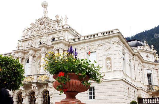 fragment of Linderhof palace with big vase and flowers in front