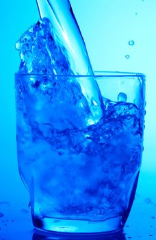 Drink theme: image of water splash in blue glass